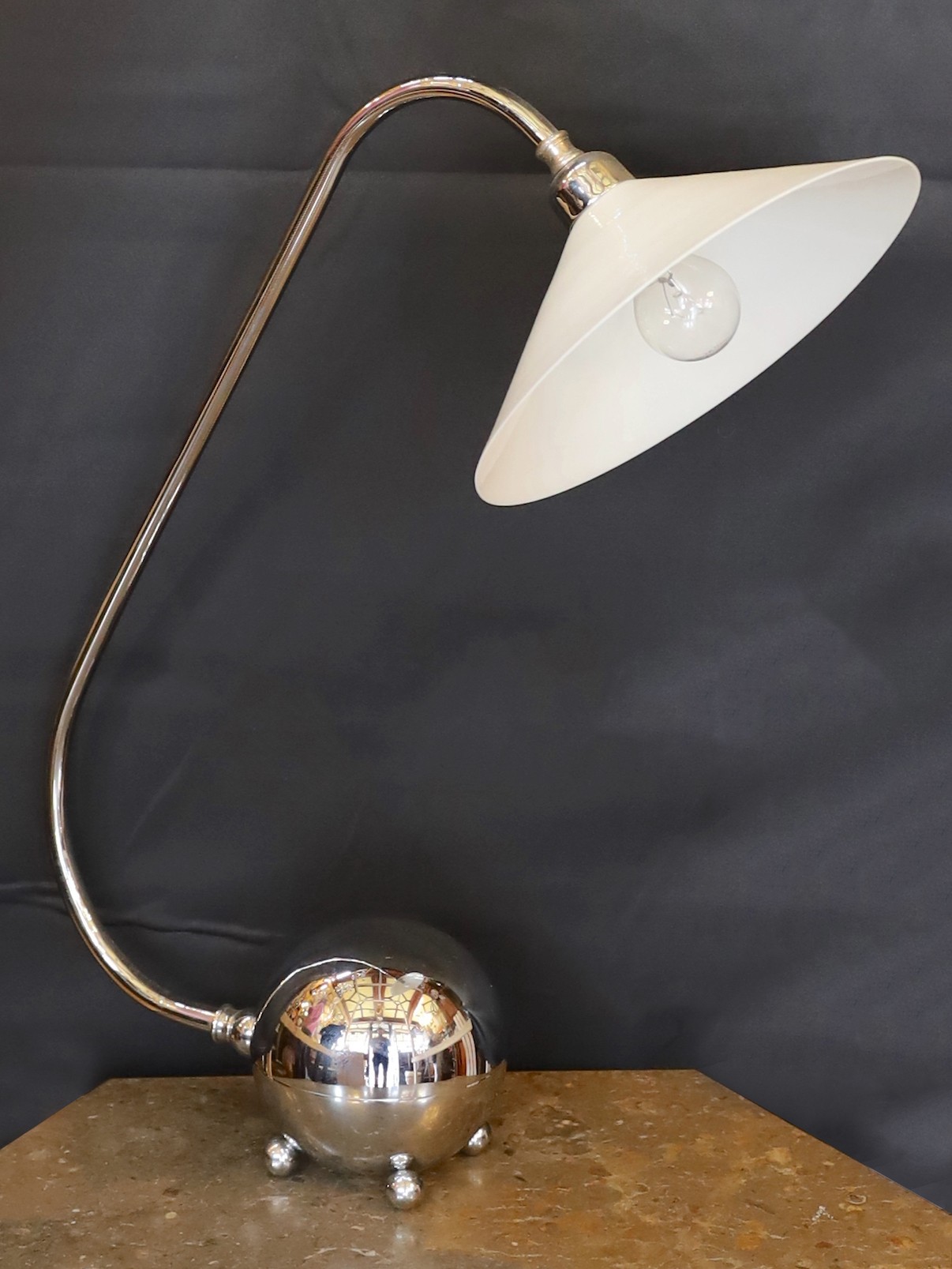 A stylish nickel plated desk lamp, with conical opaque white glass shade and loaded spherical base, height 52cm